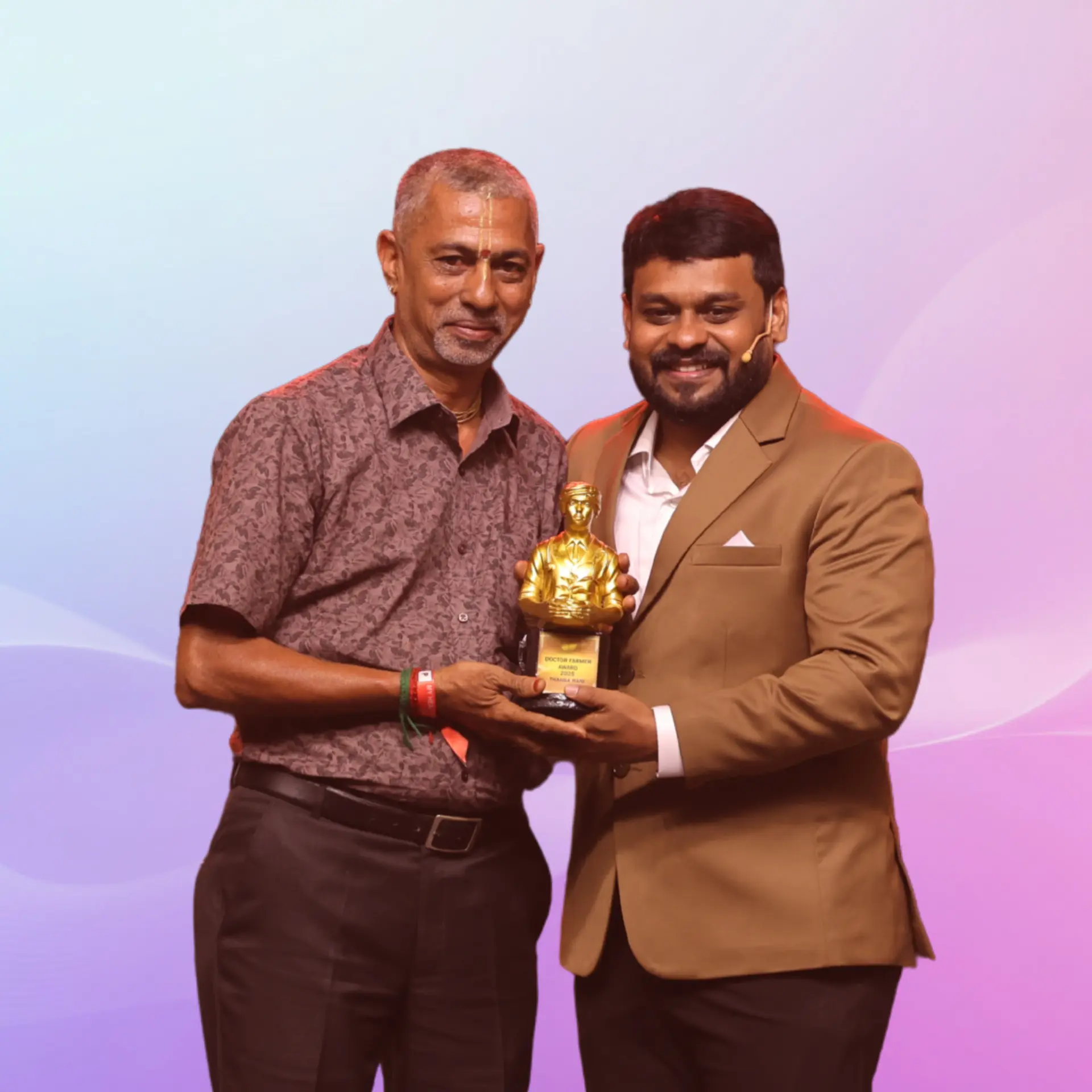 Balakumar receiving the Doctor Farmer award from Dr. Prabhakar Raj on stage